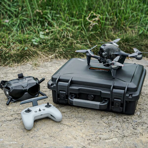 Drone with controller and goggles on case.